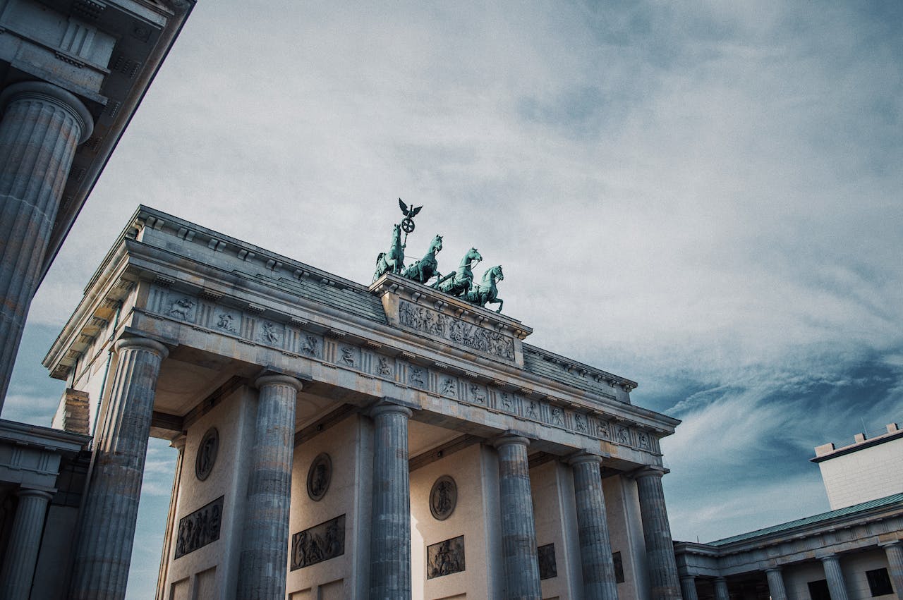 Iconic Brandenburg Gate in Berlin showcasing historical architecture against a dramatic sky.