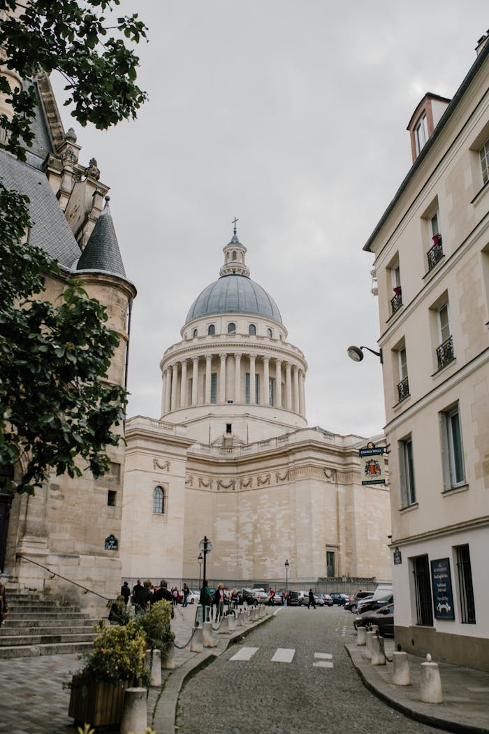 Landmark of Paris Pantheon aged monumental building built on territory of Abbey of Saint Genevieve with travelers walking around